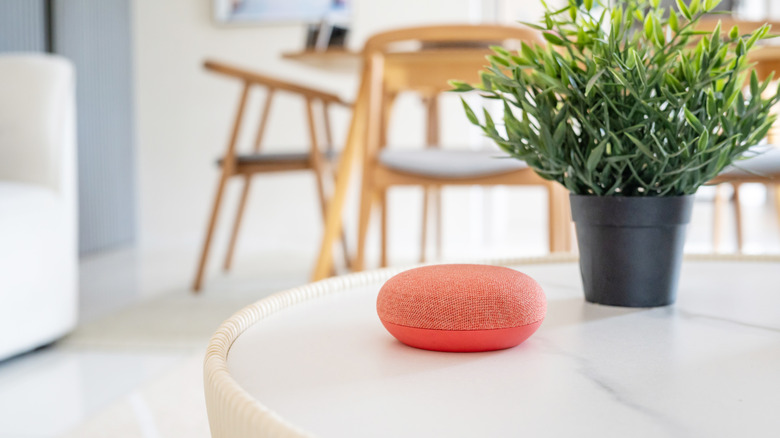 An orange Bluetooth speaker in a dining room.