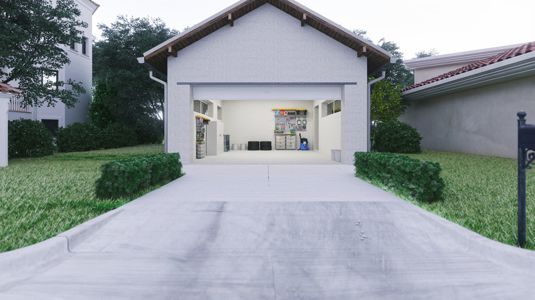 concrete driveway leading to an open home garage