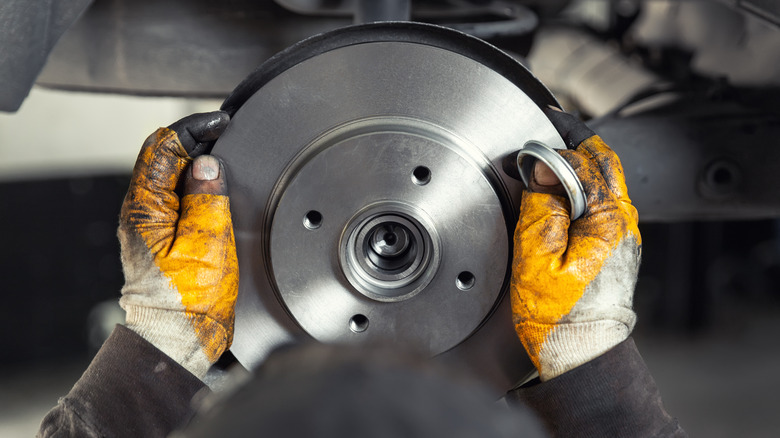 Mechanic fitting brake rotor to car