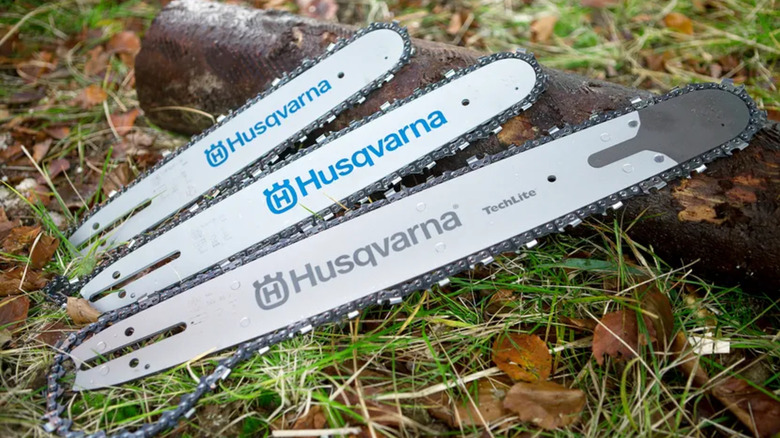 Different sized Husqvarna saw chains and guide bars on the ground
