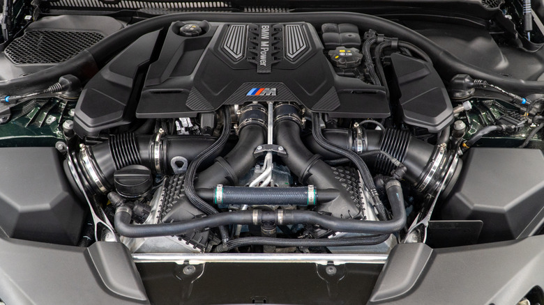 A close-up of a BMW M5 Competition V8 engine cover.
