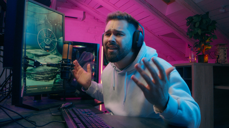Frustrated gamer wearing wireless headphones