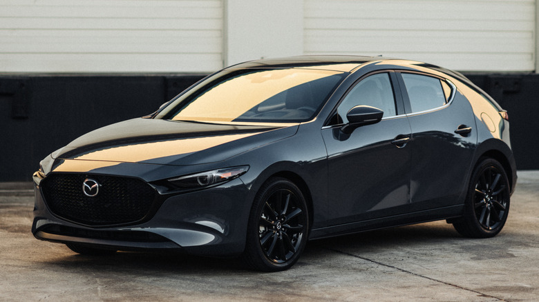 A black 2026 Mazda3 parked on concrete in low light
