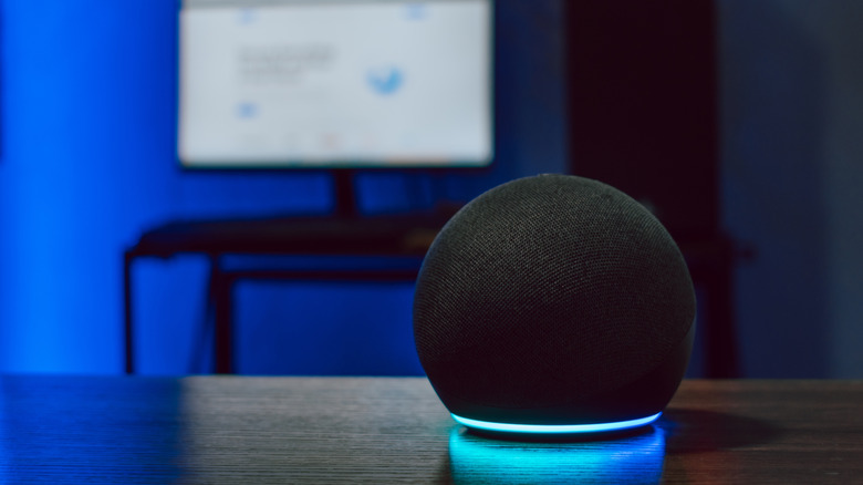 An Amazon Echo Dot placed on a wooden surface