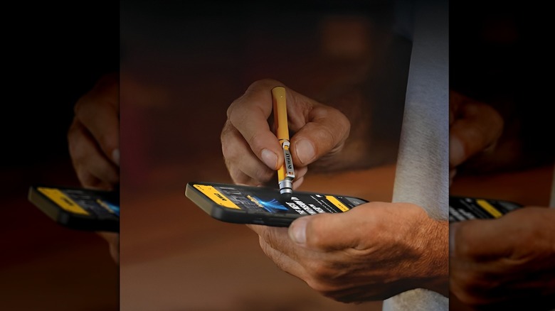 Man using DeWalt stylus on phone screen