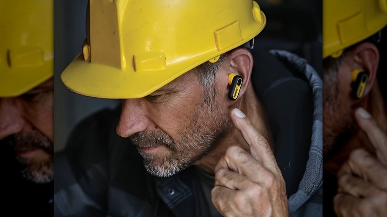 Construction worker wearing DeWalt wireless earbuds