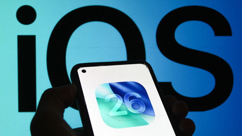 iOS 26 logo on a phone over an iOS background
