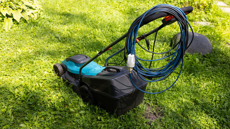 A lawn mower with its cord in a loop.