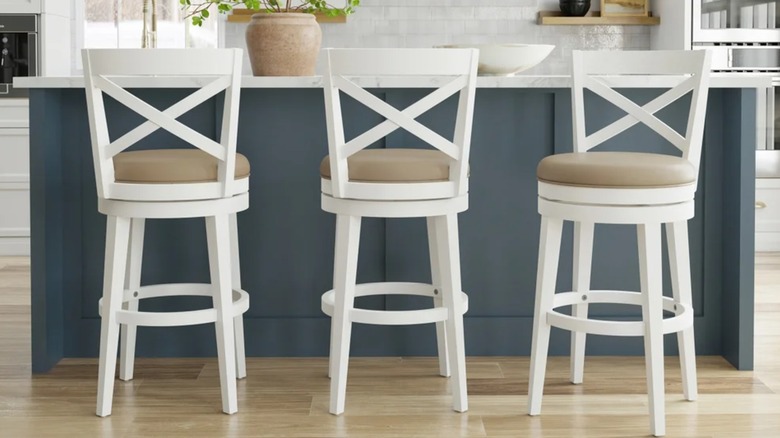 Three stools along a kitchen island.