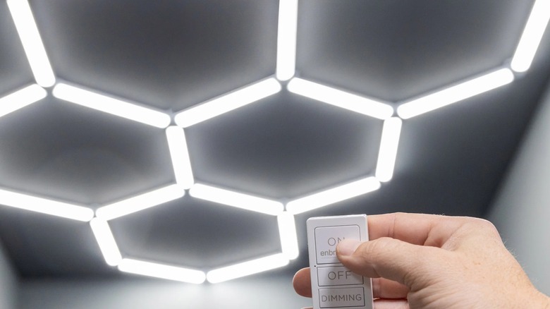 A person setting up lights using a remote.