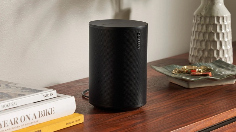 A Sonos speaker on a wood table.