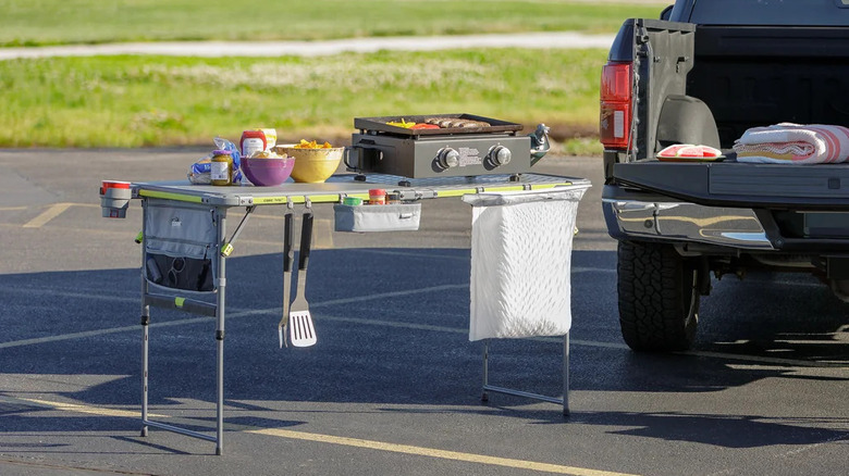 The CORE Prep & Cook FlexRail Table set up near a pickup truck