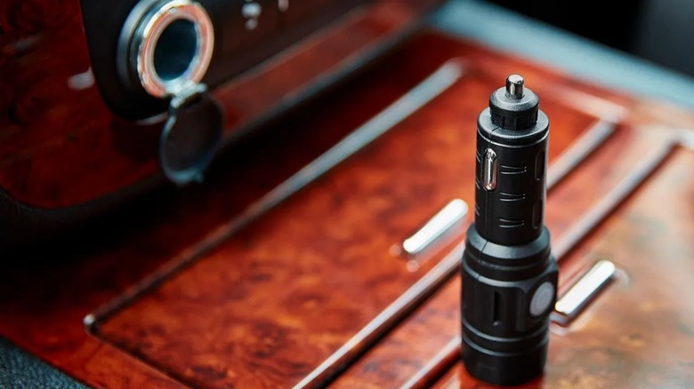a harbor freight mini 12-volt flashlight sitting on a car's center console