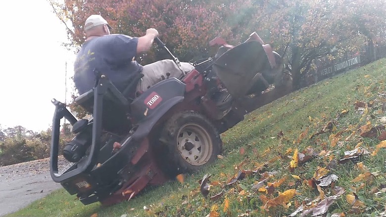 A zero-turn mowers front wheels lifting up while navigating a slope