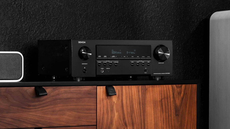 the Denon AVR-S760H next to some speakers on a wooden drawer.