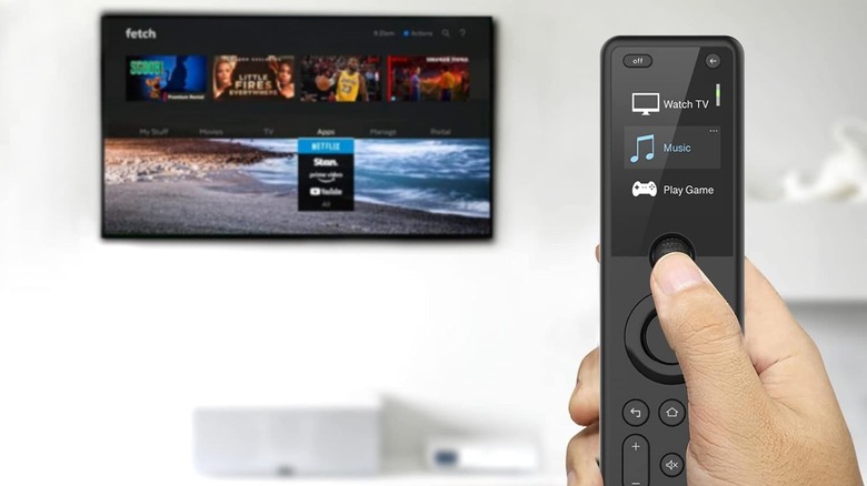 The SofaBaton X1 held in hand with a TV in the background