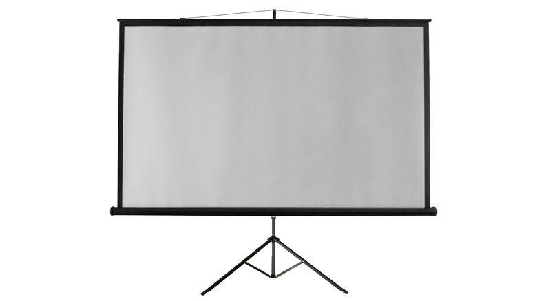 A roll-up projector screen on a tripod