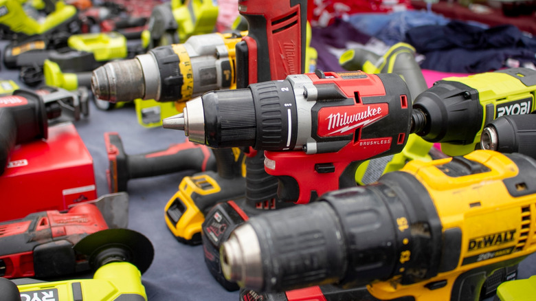Power drills from DeWalt, Milwaukee, and Ryobi at a swap meet table
