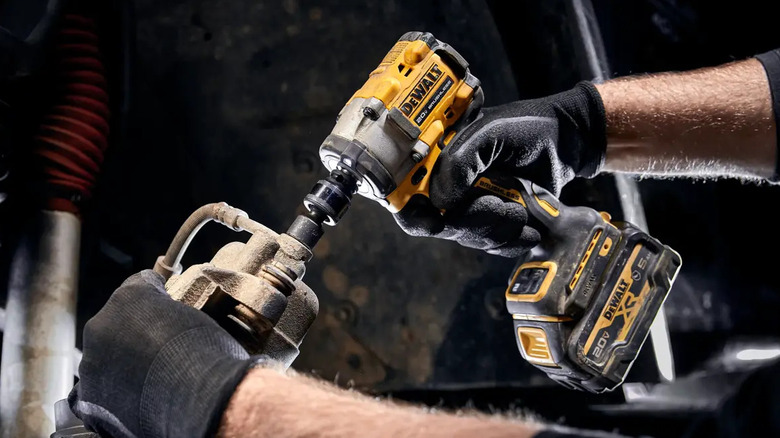 Closeup of the DeWalt 20V Max Atomic impact wrench in the hands of a worker