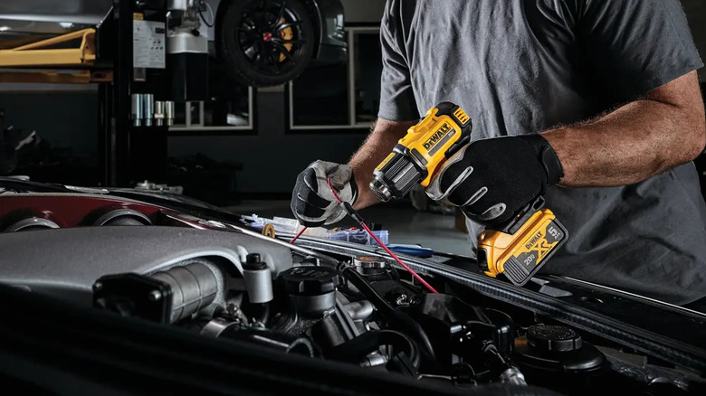 Mechanic using a DeWalt 20V Max heat gun to shrink heat wrapping