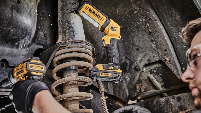 A DeWalt 20V MAX* LED Hand Held Area Light used by a worker to illuminate a job.