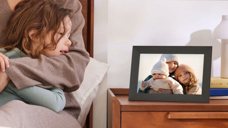 A child looking at an Aura picture frame.