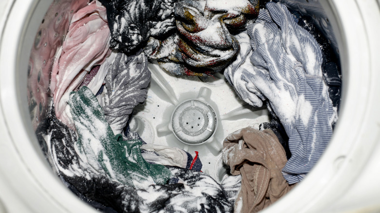 A washer full of clothes and detergent.