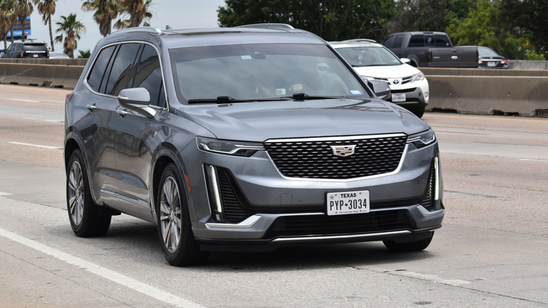 A gray Cadillac XT6 on the move on the highway, front 3/4 view
