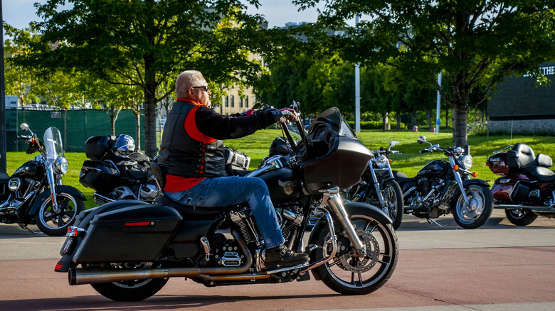 Man riding classic Harley-Davison cruiser motorcycle.