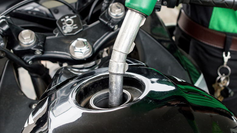 Close-up of motorcycle being refueled.