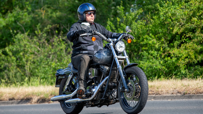 Man cautiously operating cruiser motorcycle.