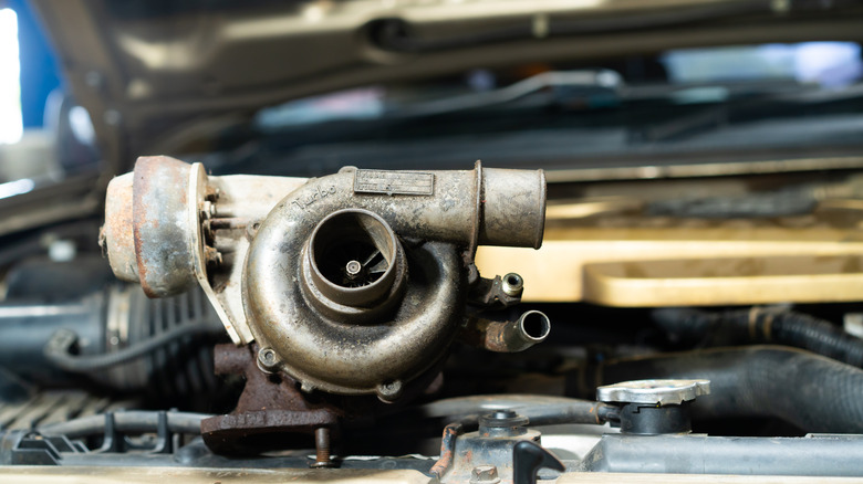 Old turbocharger on top of engine.