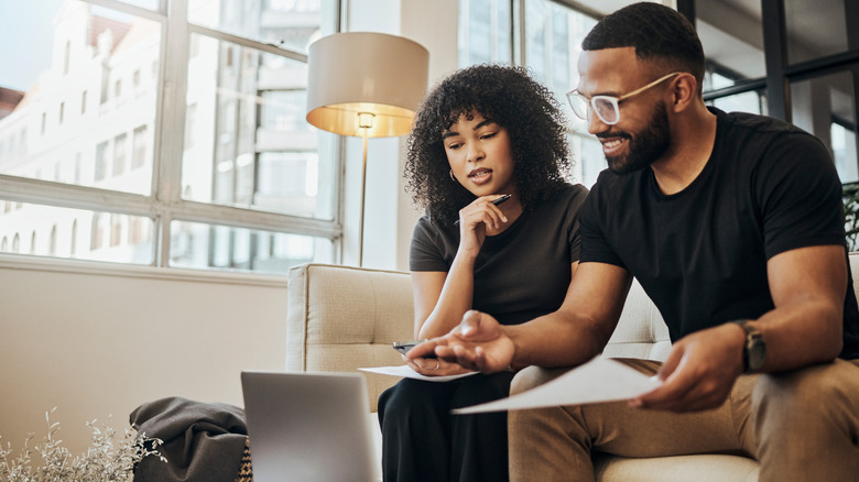 Couple looking at computer and managing bills.