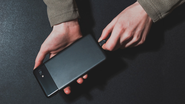 A person plugging in a Pixel phone to charge