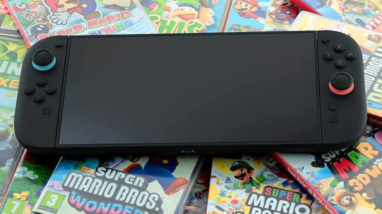 A Nintendo Switch 2 with the screen off sitting on top of a few Nintendo games