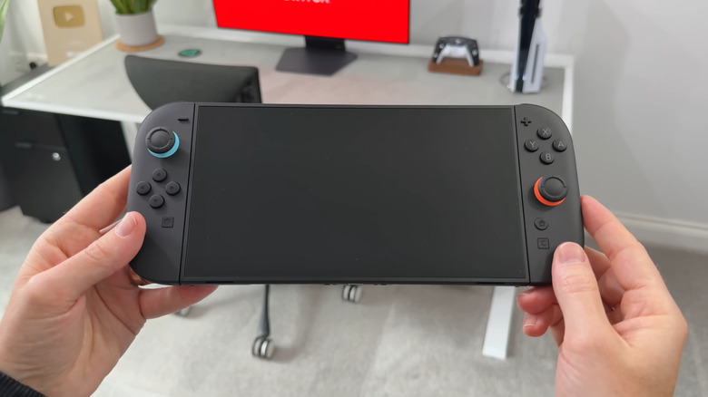 A person holding a Nintendo Switch 2, screen off