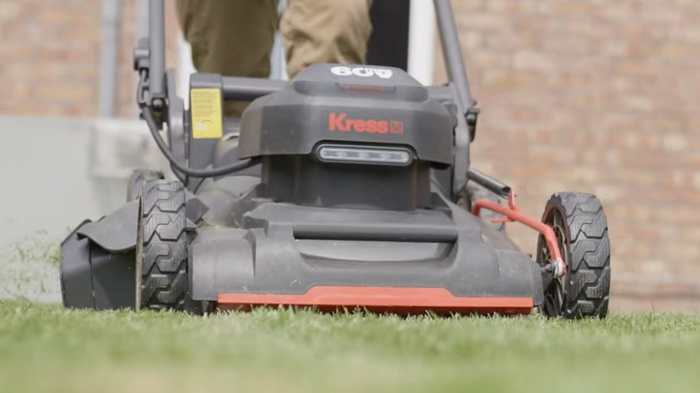 A person using a push lawn mower on grass.