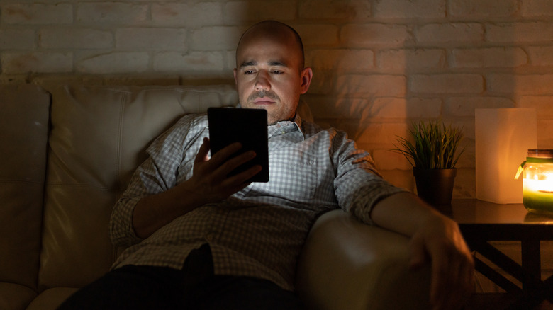 man reading an ebook at night