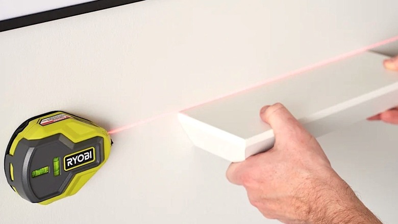 Person using AAA battery powered Ryobi AirGrip Laser Level