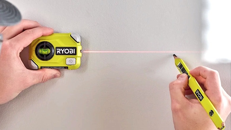 Person using AAA battery powered Ryobi Compact Laser Level