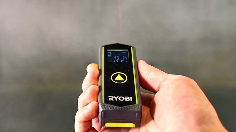 Person using AAA battery powered Ryobi Laser Distance Measurer