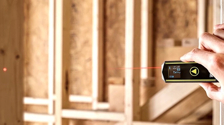 Person using AAA battery powered Ryobi Laser Distance Measurer