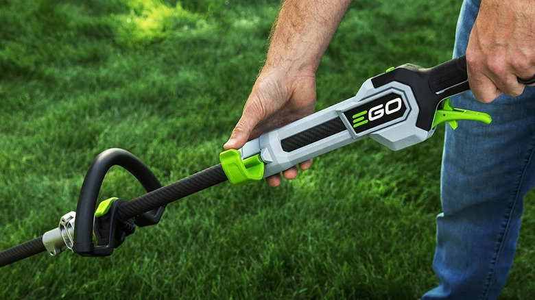 close-up of a man holding the handle of an Ego Power Plus 16-inch Powerload string trimmer