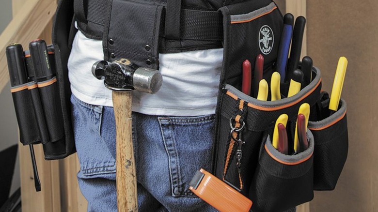 An electrician tool belt containing a selection of tools.