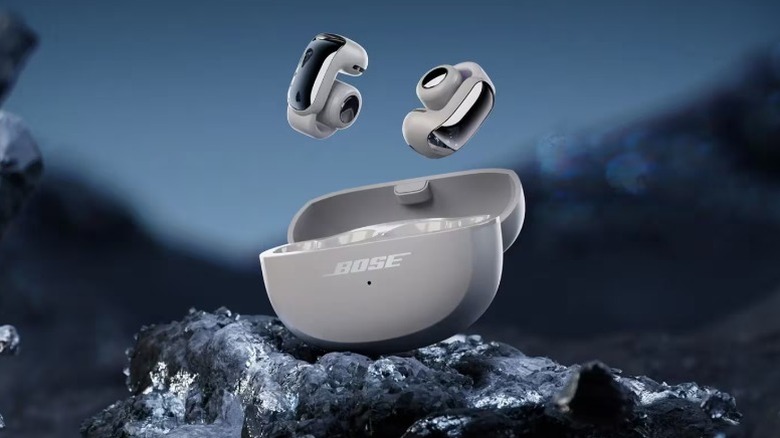 Rendering of Bose Ultra Open-Ear True Wireless Earbuds and the case in a rocky environment