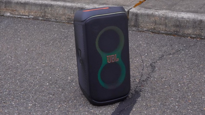 JBL PartyBox 120 Portable Party Speaker next to a sidewalk on asphalt
