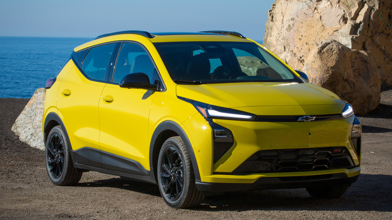 The 2027 Chevrolet Bolt in Atomic Yellow parked on a beach