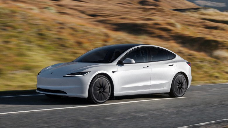 A white Tesla Model 3 on a mountain road