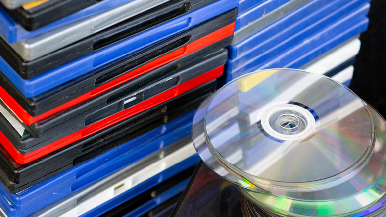 Stacks of CD/DVD boxes next to a stack of discs