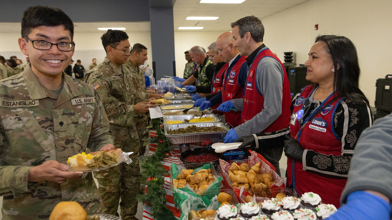 Members of the military receive food as it's being handed out by Lowe's employees.